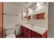 Bathroom with a cherry wood vanity, white sink, and decorative mirror at 1316 Driscoll Dr # 102, Las Vegas, NV 89128