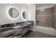Bathroom featuring a dual sink vanity, modern mirrors, and tiled shower/tub at 1601 W Calvada Blvd, Pahrump, NV 89048