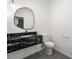 Bathroom showcasing modern black marble vanity, a toilet, and updated light fixture at 1601 W Calvada Blvd, Pahrump, NV 89048