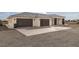 This home features a three-car garage, gray roof, minimalist front yard, and tasteful dark trim at 1601 W Calvada Blvd, Pahrump, NV 89048