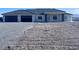 Single-story home with a gray roof, three-car garage, and minimalist front yard in a desert community at 1601 W Calvada Blvd, Pahrump, NV 89048