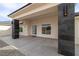 Covered front porch features stylish dark slate columns, neutral wall paint, and multi-paneled front door at 1601 W Calvada Blvd, Pahrump, NV 89048