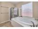Bright bathroom showcasing a soaking tub beside glass enclosed shower and window at 172 Turtle Ridge Ave, Las Vegas, NV 89183