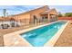 A sparkling in-ground swimming pool with a safety fence in the backyard with desert landscaping at 172 Turtle Ridge Ave, Las Vegas, NV 89183