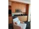 Hotel room kitchenette with wood cabinetry, stainless steel appliances, and black countertops at 2000 N Fashion Show Dr # 1728, Las Vegas, NV 89109