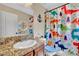 Bright bathroom featuring a granite countertop, cute dinosaur-themed shower curtain and blue accents at 2212 Barton Mill Ct, North Las Vegas, NV 89084