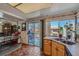 Functional kitchen featuring tile floors, wood cabinets, a double stainless steel sink, and a sliding glass door at 2375 Rawhide St, Las Vegas, NV 89119