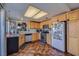 Efficient kitchen featuring tile floors, wood cabinets, stainless steel appliances, and ample natural light at 2375 Rawhide St, Las Vegas, NV 89119