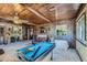 Living room featuring wood ceiling, a fireplace, and a pool table, creating a distinctive and inviting entertainment space at 2375 Rawhide St, Las Vegas, NV 89119