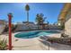 Backyard pool with a covered patio, landscaping, and the home exterior creates an inviting outdoor space at 2375 Rawhide St, Las Vegas, NV 89119