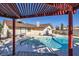 Backyard pool with a covered patio, landscaping, and the home exterior creates an inviting outdoor space at 2375 Rawhide St, Las Vegas, NV 89119