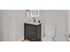 Modern half bathroom featuring a dark vanity with white countertop and toilet at 2402 El Cid Ct, Henderson, NV 89014