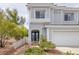 Attractive townhome showcasing a gray stucco exterior, two-car garage, and landscaped front yard for curb appeal at 2405 Esteem Ridge Dr, Henderson, NV 89052