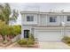 Stylish townhome features gray exterior, a two-car garage, and tasteful landscaping for a welcoming curb appeal at 2405 Esteem Ridge Dr, Henderson, NV 89052