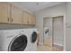 Functional laundry room with appliances, wooden cabinets and closet at 2405 Esteem Ridge Dr, Henderson, NV 89052