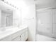 Bathroom with double sinks, a large mirror, and a tub shower featuring glass doors at 2647 Jacyra Ave, Las Vegas, NV 89121