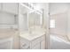 Bright bathroom featuring a vanity with storage, mirror, and access to the adjacent bedroom at 2647 Jacyra Ave, Las Vegas, NV 89121