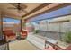 Relaxing covered patio with comfortable seating, ceiling fan, and views of the backyard at 2705 Cuckoo Shrike Ave, North Las Vegas, NV 89084