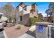 Two-story tan condo with stucco, red-tile roof, well-maintained landscaping, and reserved parking at 2966 Juniper Hills Blvd # 204, Las Vegas, NV 89142