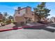 Two-story tan condo with stucco, red-tile roof, well-maintained landscaping, and a blue sky at 2966 Juniper Hills Blvd # 204, Las Vegas, NV 89142