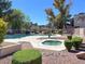 Community pool with a hot tub surrounded by trees and landscaping at 2966 Juniper Hills Blvd # 204, Las Vegas, NV 89142