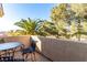 Private balcony features an iron table set amidst lush trees and clear blue sky views at 3098 Quail Crest Ave, Henderson, NV 89052