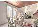 Open-concept dining area with a glass-top table and seamless flow to the living room at 3098 Quail Crest Ave, Henderson, NV 89052