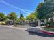 Community entry gate with mature trees, manicured landscaping, and wrought iron fencing at 3098 Quail Crest Ave, Henderson, NV 89052