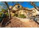 Charming two-story home with a tile roof, a two-car garage, mature trees, and gravel front yard at 3098 Quail Crest Ave, Henderson, NV 89052