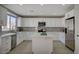 Bright kitchen with stainless steel appliances, white cabinets and grey backsplash and an island at 316 Blackstone River Ave, Las Vegas, NV 89148