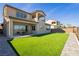 Beautiful backyard featuring a well-manicured lawn, a covered patio, and a two-story home at 350 Gandara St, Las Vegas, NV 89138