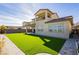 Spacious backyard featuring lush artificial turf, a covered patio, and an elegant two-story home at 350 Gandara St, Las Vegas, NV 89138