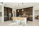 A modern kitchen featuring dark wood cabinets, granite countertops, a stainless steel refrigerator, and pendant lighting at 350 Gandara St, Las Vegas, NV 89138