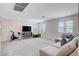 Spacious bonus room featuring an exercise bike, storage cabinet, and a large flat screen television at 3524 Crotone Ave, Henderson, NV 89044