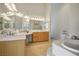Bright bathroom features a dual sink vanity, soaking tub and neutral tile floors at 404 Via Sonador, Henderson, NV 89012