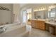 Bathroom showcases a soaking tub and dual sink vanity with access to the main bedroom at 404 Via Sonador, Henderson, NV 89012