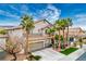 Two-story home with desert landscaping, mature palm trees, tile roof and attached garage at 404 Via Sonador, Henderson, NV 89012