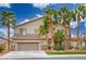 Charming two-story home with a two-car garage, complemented by manicured landscaping and stately palm trees at 404 Via Sonador, Henderson, NV 89012