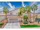Spacious two-story home featuring mature palms, desert landscaping, a tile roof and front yard bench at 404 Via Sonador, Henderson, NV 89012