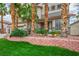 Charming home with lush lawn, mature palm trees, and a brick retaining wall showcasing curb appeal at 404 Via Sonador, Henderson, NV 89012