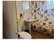 Small bathroom with floral shower curtain, pedestal sink, and toilet at 424 Jefferson Blvd, Henderson, NV 89011