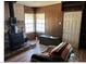 Living room featuring wood burning stove, wood paneled walls, and laminate flooring at 424 Jefferson Blvd, Henderson, NV 89011