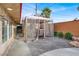 Relaxing outdoor patio with a stone floor, brick wall, lovely gazebo, and desert plants at 5005 Harmony Ave, Las Vegas, NV 89107
