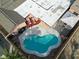 An aerial view of a kidney shaped pool in a backyard with a lounge and shaded patio at 5005 Harmony Ave, Las Vegas, NV 89107