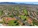 Expansive aerial view of a well-planned community nestled amidst lush green golf courses and scenic landscapes at 5104 Elm Grove Dr, Las Vegas, NV 89130