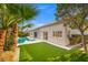 Expansive backyard featuring an inviting pool, verdant lawn, and mature trees for outdoor enjoyment at 5104 Elm Grove Dr, Las Vegas, NV 89130