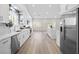 Open-concept kitchen showcasing a large island, stainless steel appliances, quartz countertops, and wood-look flooring at 5104 Elm Grove Dr, Las Vegas, NV 89130