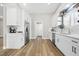 Modern white kitchen featuring stainless steel appliances, quartz countertops, and stylish wood-look flooring at 5104 Elm Grove Dr, Las Vegas, NV 89130