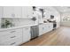 Bright kitchen with stainless steel appliances, white cabinets, and quartz countertops, complemented by wood-look flooring at 5104 Elm Grove Dr, Las Vegas, NV 89130