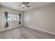 Bedroom with wood floors, ceiling fan, and window with curtains at 513 Elm St, Boulder City, NV 89005